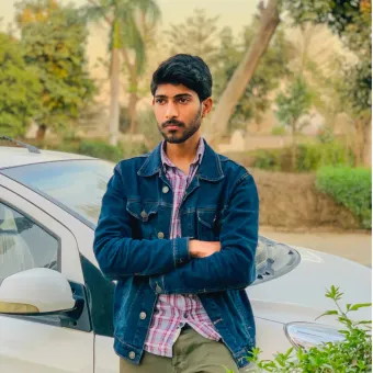 Jawad leaning on a car